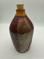 Front view of stoneware vase showing glaze colours and cork