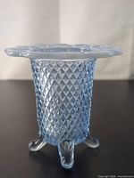 Full view of blue opalescent three-footed vase