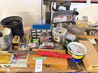 Wide view of bench showing majority of tools, buckets, DeWalt blade, Milwaukee saw body, organisers