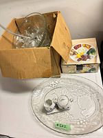 Cardboard box with glass punch bowl, glass platter leaning, boxed divided tray