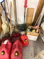 Group showing gas cans, rakes, shovel, trimmer, box of misc tools