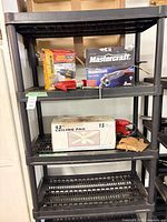 Overall lot on shelving showing boxed tools, ceiling fan, gloves, shelving