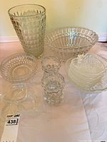 Group shot showing all pressed glass items including tall vase, ribbed bowl, apple bowls and small vases
