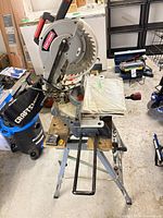 Overall view of Craftsman miter saw mounted on folding stand with dust bag attached