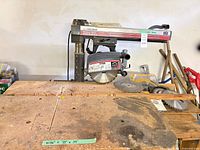 Radial arm saw on wooden bench with accessories in view