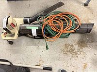 Entire lot showing leaf blower motor unit, blower tubes, collection bag and coiled extension cords