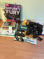 Group shot showing binoculars, books stack, locks, envelopes, accessories
