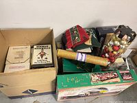 Overview showing boxed collector plates, Norman Rockwell book, ornaments, pillows, ribbon, train set