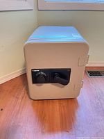 Front view of Sentry 1250 safe showing beige finish, black combination dial and handle