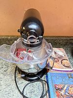 Overall view of mixer with bowl, shield, cord and cookbooks