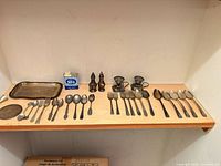 Full view of all flatware, shakers, trays and strainers on shelf