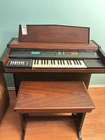 Front view of Wurlitzer organ console with matching bench