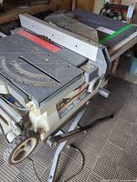 Overall view of table saw on folding stand with rip fence attached