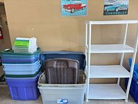 Overall view of stacked totes in various colors next to shelving unit