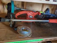Overall view of Black & Decker trimmer, Yardworks charger and line spool on shelf