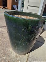 Full view of dark green ceramic planter outdoors
