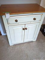 Front view of cabinet showing drawer, doors, knobs, overall appearance