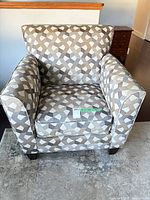 Front view of armchair showing overall design, upholstery pattern, seat cushion, wood legs