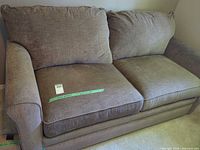 Front view of loveseat showing two seat and back cushions, rolled arms, upholstery, size