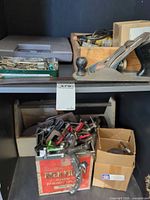 Overview of shelves showing plane, clamps, bits, boxes