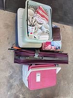 Stacked lot showing both Coleman coolers, plastic basket with kitchenware, linens and purple chair bag