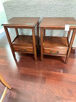 Pair of matching brown veneer end tables front view
