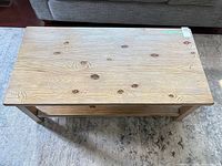 Top view of rectangular light wood coffee table showing wood-grain surface and lower shelf