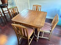 Square dining table with 4 chairs around, leaves retracted