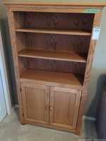 Front view of solid oak bookcase showing two shelves and lower cabinet