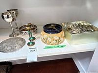 Full lot overview showing cigar jar, goblets, plates, flatware box