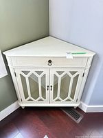Front corner cabinet showing drawer, glass doors, lattice detail
