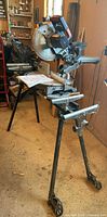 Saw mounted on rolling stand with manual on table