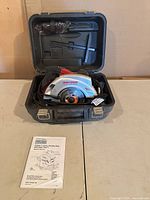 Circular saw in open carrying case with manual and accessories visible