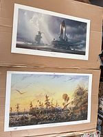 Both posters stacked on cardboard backing showing full artwork