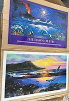 Both posters laid out on cardboard backing showing full artwork