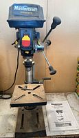Full view of Mastercraft bench drill press on base with manual visible