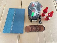 Overview showing atlas, rotating display with cord, pair of red glass lamps, stack of ten coasters