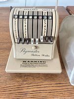 Front view of Paymaster 8000B check writer showing denomination levers and logo