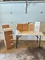 Stacked bulk cartons and inner boxes of poly bags on and beside table