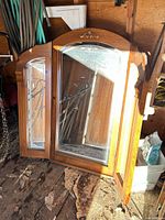 Front view of tri-fold mirror showing beveled glass and wood frame