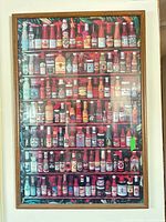 Full view of framed poster showing bottle imagery