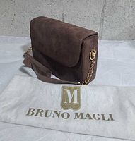 Front/side view showing suede flap, gold-tone chain strap, Bruno Magli dust cover