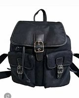Front view showing flap buckle, drawstring, two front pockets, leather trim, hardware