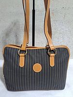 Front view of striped Fendi tote showing logo patch, straps and trim