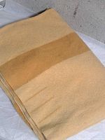 Folded tan wool blanket with darker tan stripe