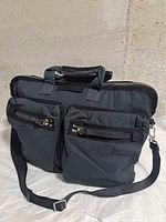 Front view showing two zip pockets, top handles, strap