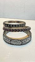 Three silvertone rhinestone bangles stacked