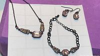 Full view of necklace, bracelet and earrings laid out