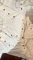 Duvet cover and pillowcases spread out showing button details