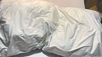 Full view of white Biloban body pillow lying flat